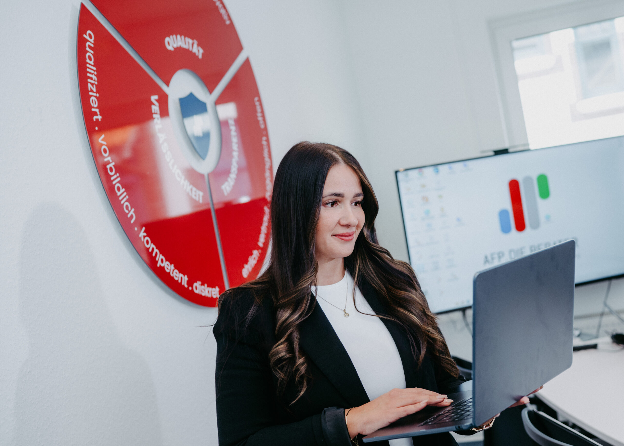 Eine Frau im Büro, die am Laptop arbeitet.