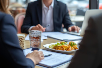 Beratungssituation in einem Restaurantbüro mit Unterlagen und Laptop
